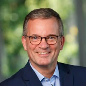 Porträt eines Manns vor grünem Hintergrund.