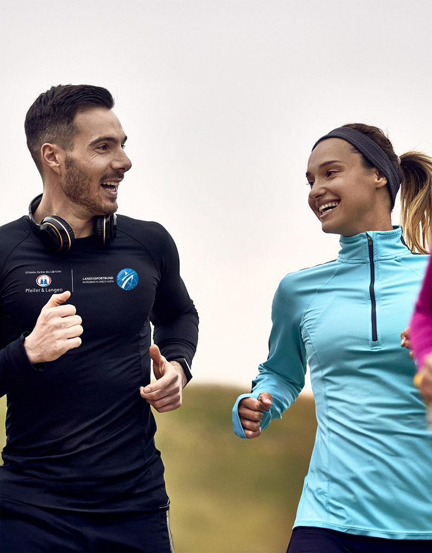 Zwei Personen joggen gemeinsam und unterhalten sich dabei.
