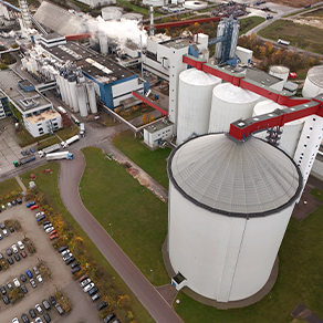 Luftaufnahme einer Industrieanlage mit großen Silos und Produktionsanlagen.