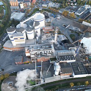 Luftaufnahme einer Industrieanlage mit Silos, Gebäuden und Produktionsanlagen.